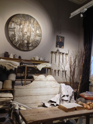 The natural room with a giant clock and some wool combs hanging on the wall.