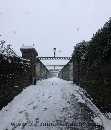 A bridge with a Narnia style lamp on the top, heavy snow falling.