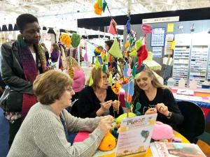 Knitters wanting to learn how to crochet at the UKHKA stand.