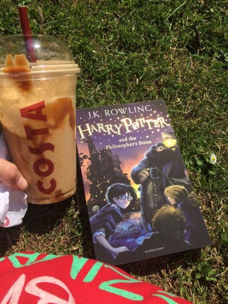 Enjoying Harry Potter in the sun with a coffee.