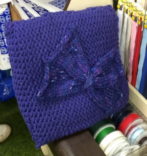 A beautiful knitted cushion in the shop.