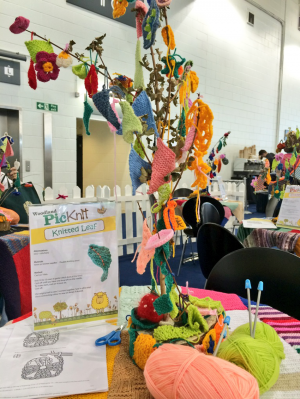 Trees decorated with knitted and crochet leaves.