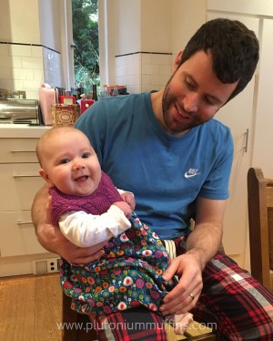 Baby Cara wearing the Spanish Dress, sitting on daddy's knee.