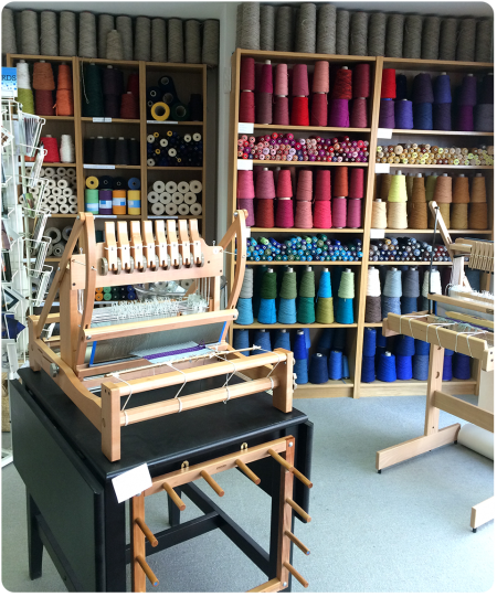 Yarns and looms in the front of the shop.